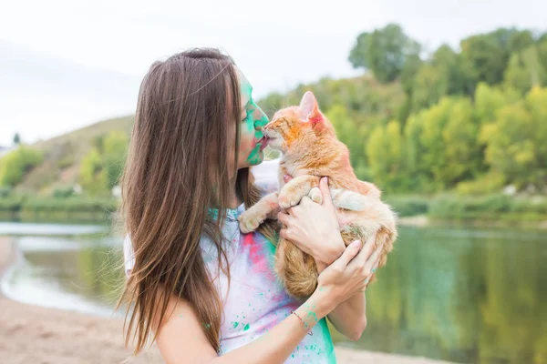 축제 holi, 공휴일, 여름 관광 및 자연 개념-자연 배경 색깔의 먼지에서 고양이 함께 젊은 매력적인 여자 — 스톡 사진