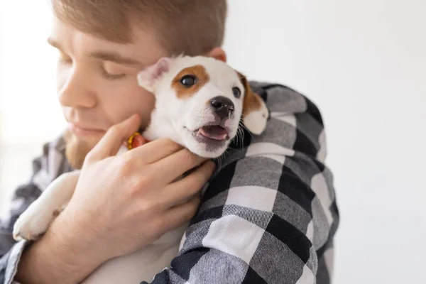Gente y concepto de mascota - Hombre feliz sosteniendo un perro Jack Russell Terrier de cerca — Foto de Stock