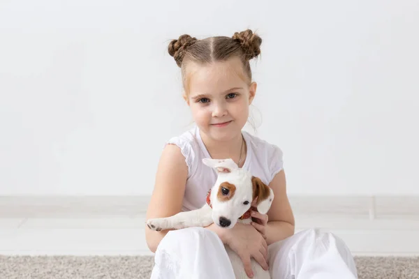 Husdjur och djur koncept - barn flicka som leker med valp Jack Russell Terrier — Stockfoto