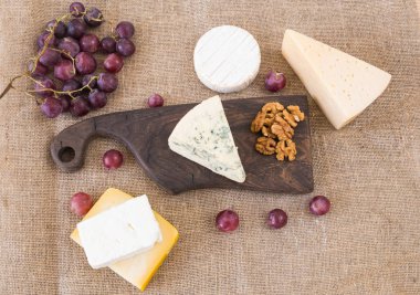 Taze ürünler. Peynir, brie, Camembert, üzüm ve fındık rustik masa.