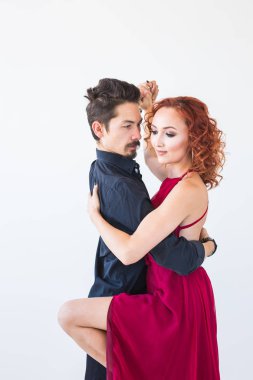 Sosyal dans, bachata, kizomba, salsa, tango kavramı - beyaz arka plan üzerinde kırmızı elbise ve siyah kostümlü adam giymiş kadın