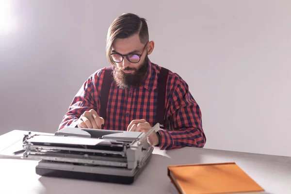 Gente, escritor y concepto hipster - joven escritor elegante que trabaja en la máquina de escribir — Foto de Stock