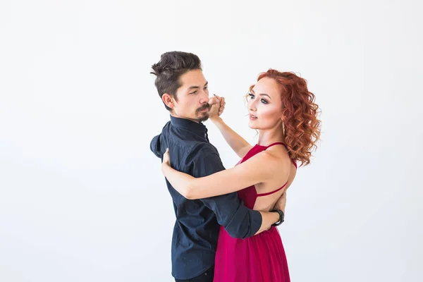 Dança social, bachata, kizomba, salsa, conceito de tango - Mulher vestida de vestido vermelho e homem em um traje preto sobre fundo branco — Fotografia de Stock