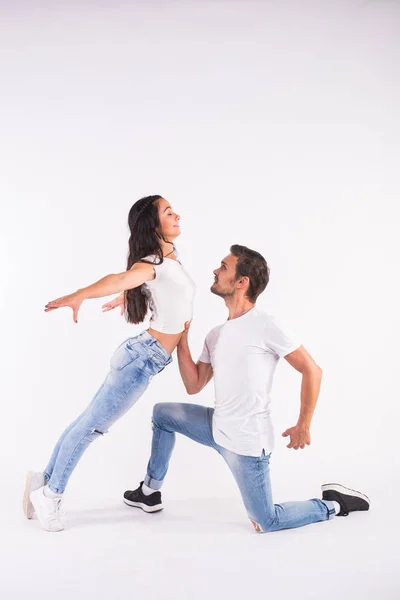 Молодая пара танцует социальные латинские танцы бачата, меренге, сальса. Две элегантные позы на белом фоне — стоковое фото