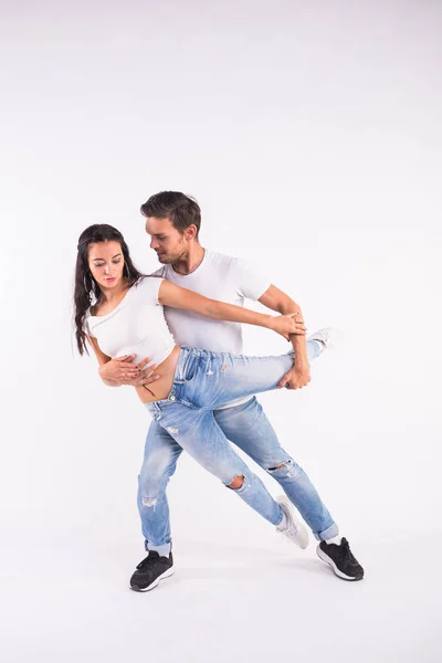 Mladý pár tančící sociální latinské tance bachata, merengue, salsa. Představují dva eleganci na bílém pozadí — Stock fotografie