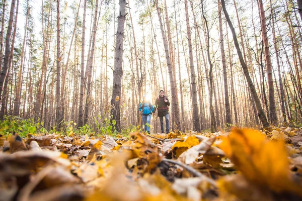 Macera, seyahat, turizm, yürüyüş ve insanlar kavramı - gülümseyen çift sırt çantaları ile sonbahar doğal arka plan üzerinde yürüme — Stok fotoğraf