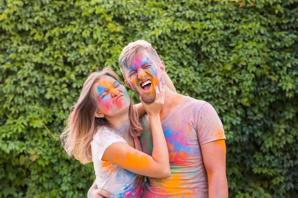 Amistad, festival de holi, concepto de personas - pareja joven jugando con colores en el festival de holi — Foto de Stock