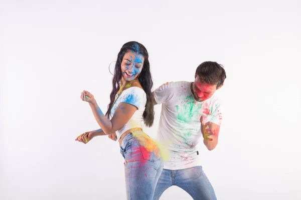 Концепция праздников, холи и людей - счастливая пара веселится с разноцветным порошком на их лицах на белом фоне — стоковое фото