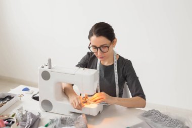 İnsanlar, terzi ve moda kavramı - portre çalışma yer moda tasarımcısı dikiş makinesi ile yakından