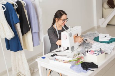 Terzi, terzi, işleri ve terzi kavramı - yüksek açı görünüm portre dikiş makinesi kullanarak gözlük gülümseyen moda tasarımcısı