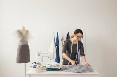Terzi, moda tasarımcısı ve terzi kavramı - genç kadın Tasarımcısı hafif kumaş keser