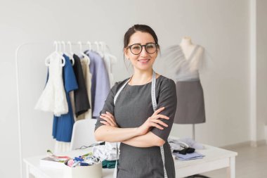 Terzi, moda tasarımcısı, terzi ve insanlar kavramı - güzel moda kadın Tasarımcısı stüdyoda ayakta