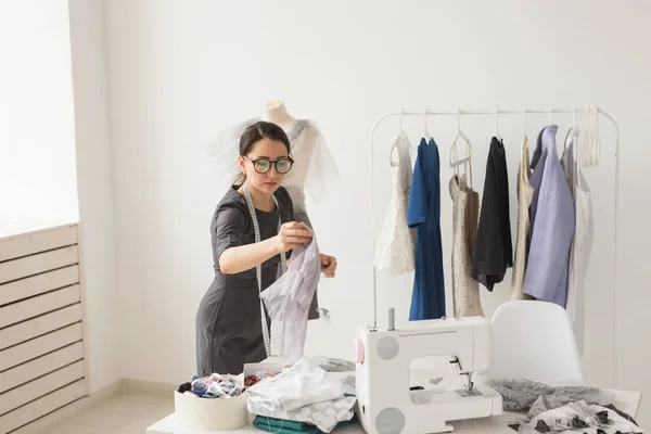 Dressmaker, tailor, fashion and showroom concept - Portrait of talented female dressmaker working with textile for sewing clothes