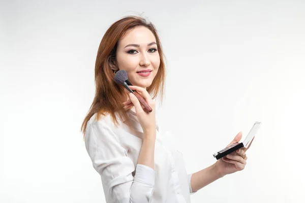 Visagistin, Schönheits- und Kosmetikkonzept - koreanische Visagistin mit Make-up-Pinseln und Lidschatten-Palette auf weißem Hintergrund — Stockfoto