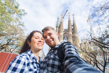 Barcelona, İspanya - 6 Şubat 2018: mutlu çift selfie fotoğraf ünlü Sagrada Familia Katolik Katedrali önünde yapma. Barselona bölgesindeki seyahat