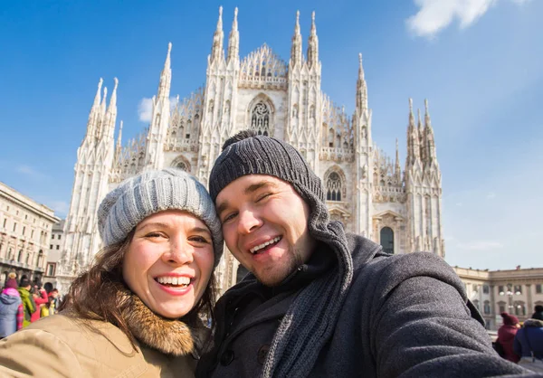 Забавная пара делает автопортрет на площади Дуомо в Милане. Зимние путешествия, Италия и концепция отношений — стоковое фото