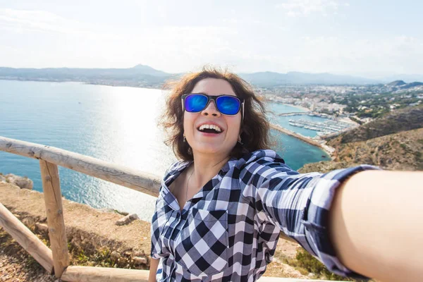 Vakantie-, vakantie- en reisinformatie concept - Happy jonge vrouw selfie overname prachtige landschap — Stockfoto