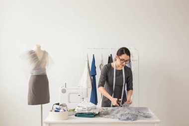 Terzi, moda tasarımcısı ve terzi kavramı - genç kadın Tasarımcısı hafif kumaş keser