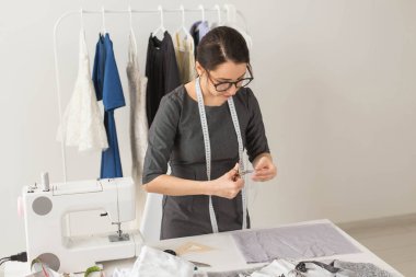 Terzi, moda tasarımcısı ve terzi kavramı - genç kadın tasarımcı, bir elbise yaratma süreci