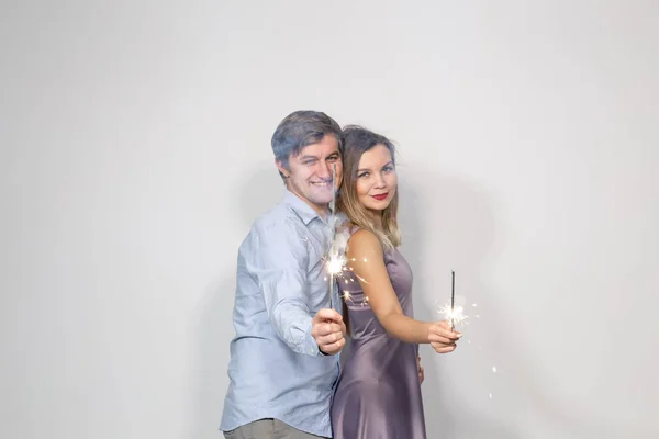休日、パーティーやお祝いのコンセプト - 白い背景の花火と若いカップル — ストック写真