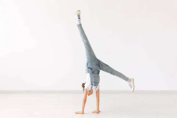 Lidé, sport a děti koncept - hezká holčička dělá gymnastiku nad bílým pozadím — Stock fotografie