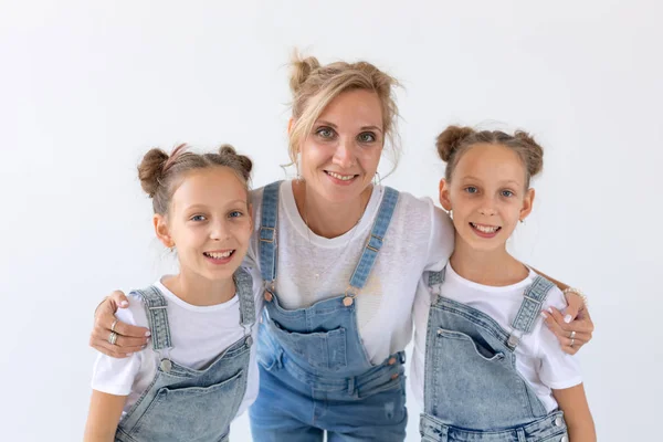 Concepto de personas, familia e hijos - hermanas gemelas con su madre sobre fondo blanco — Foto de Stock