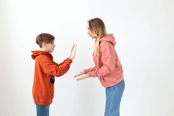 Relatie, Moederdag, kinderen en familie concept - tiener jongen geven hoge vijf aan zijn moeder op witte achtergrond — Stockfoto