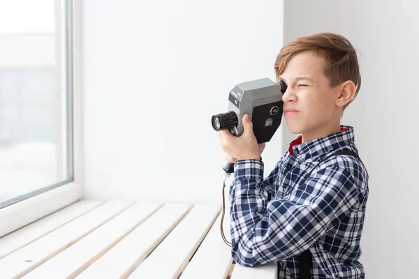 Fotograaf, kinderen en hobby concept - schattige tiener jongen poseren met retro camera op witte achtergrond — Stockfoto