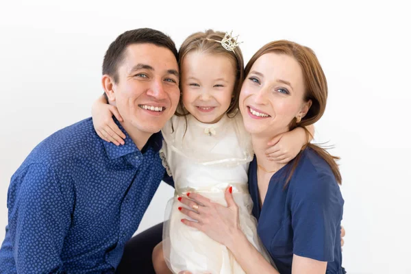 Concepto de personas, familia y felicidad - Madre y padre con hija pequeña sobre fondo blanco —  Fotos de Stock