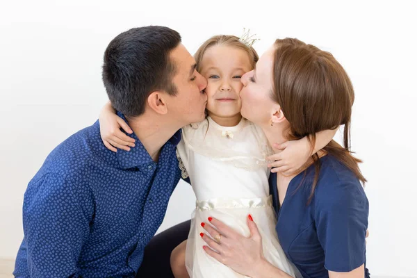 Concepto de familia, padres e hijos - Familia encantadora con una pequeña hija linda sobre fondo blanco — Foto de Stock