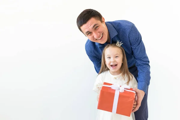 Peopel, paternidad y concepto familiar - papá feliz sosteniendo una caja de regalo con su hija sobre fondo blanco con espacio para copiar —  Fotos de Stock