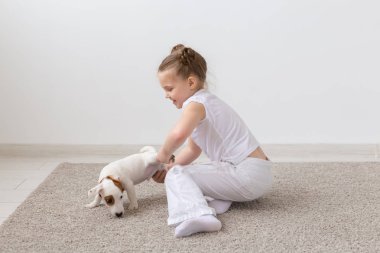 Evde beslenen hayvan, çocuk ve hayvan kavram - bir köpek yavrusu pençe tarafından tutan kız çocuk