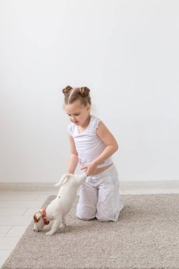 Evde beslenen hayvan, çocuk ve hayvan kavram - bir köpek yavrusu pençe tarafından tutan kız çocuk