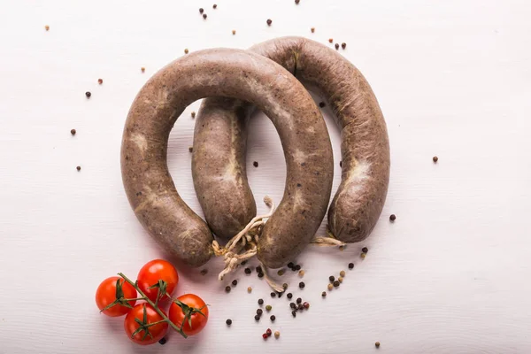 Food, horse meat and delicious concept - sliced sausage with tomato and pepper — Stock Photo, Image