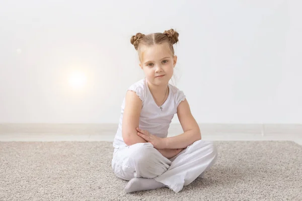 Barn och kids concept - porträtt av vackra lilla barn flicka i ljusrummet bakgrunden — Stockfoto