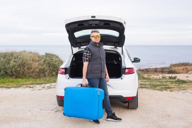 Seyahat, tatil ve tatil kavramı - adamın yanında araba mavi çanta