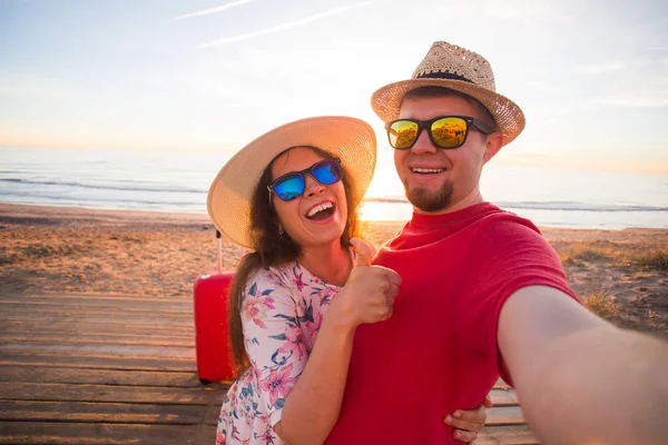 Reise, Sommer und Urlaubskonzept - schönes Paar beim Selfie am Strand — Stockfoto