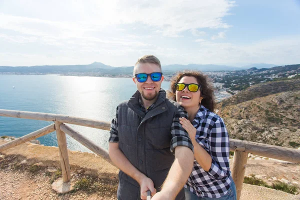 Viagens, férias e férias conceito - casal feliz tomando selfie sobre bela paisagem — Fotografia de Stock