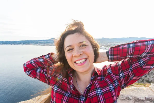 Geluk, emoties en reizen concept - lachen sproeten vrouw met krullend haar buitenshuis — Stockfoto