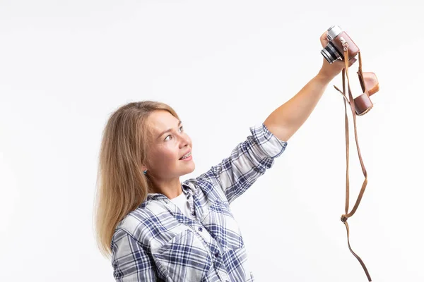 Technologieën, fotograferen en mensen concept - blonde jonge vrouw met retro camera glimlachen op witte achtergrond — Stockfoto