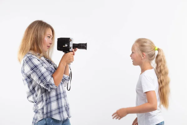 Foto, fotógrafo y concepto de cámara retro - mujer joven usando cámara vintage sobre fondo blanco — Foto de Stock