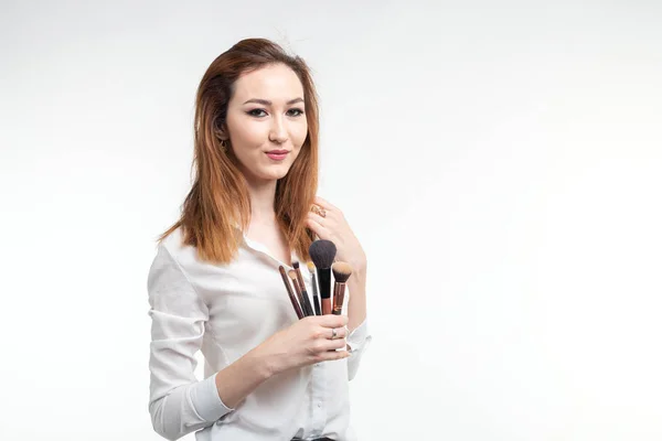 Maquillaje artista, belleza y cosméticos concepto coreano artista de maquillaje femenino con pinceles de maquillaje sobre fondo blanco con espacio de copia — Foto de Stock