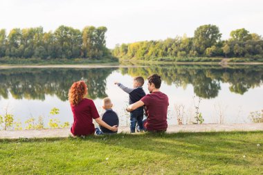 Çocuklar, ebeveynlik ve doğa kavramı - çim üzerinde oturan büyük aile