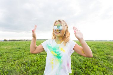 Eğlenceli, holi Festivali ve tatil kavramı - komik kadın doğa arka plan üzerinde gülümseyen renk toz kaplı