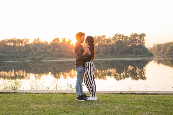 Conceptul de dragoste, romantic și natură - cuplu tânăr îmbrățișându-se lângă lac — Fotografie, imagine de stoc