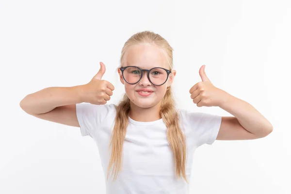 Hermosa niña con gafas que muestran los pulgares hacia arriba aislado en blanco —  Fotos de Stock