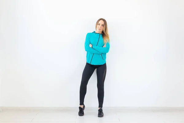 Mensen, fitness en sport concept - mooie fit vrouw gekleed in sportkleding poseren op witte achtergrond — Stockfoto