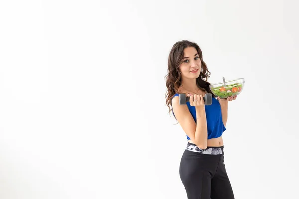 Sport, zdravý životní styl, koncepce lidí - mladá brunetka se salátem a činkou. Usmívá se a užívá si zdravého životního stylu — Stock fotografie