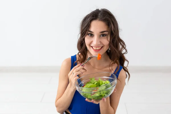 Comida, estilo de vida saudável, conceito de pessoas - Mulher jovem comendo salada e sorrindo — Fotografia de Stock