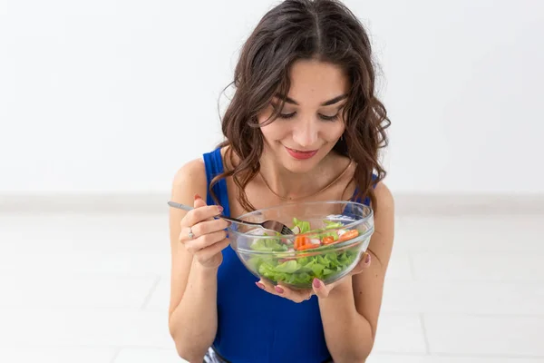Élelmiszer, egészséges életmód, emberek koncepció - saláta evés és mosolygó fiatal nő — Stock Fotó